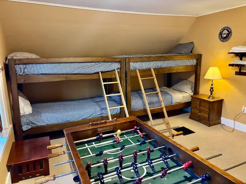 Bunk room with two twin bunk beds and foosball table