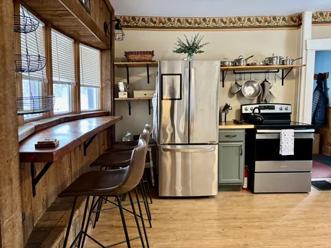 Kitchen breakfast counter beside stainless-steel refrigerator